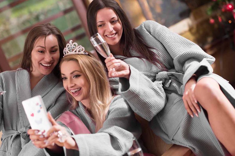 group of female friends in spa have fun and making selfie photo with mobile phone, celebrate bachelorette party